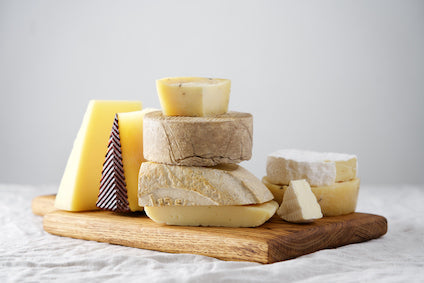 Artisan Italian and French cheeses including Parmigiano Reggiano, Brie, and aged goat cheese – gourmet cheese collection at We Do Gourmet